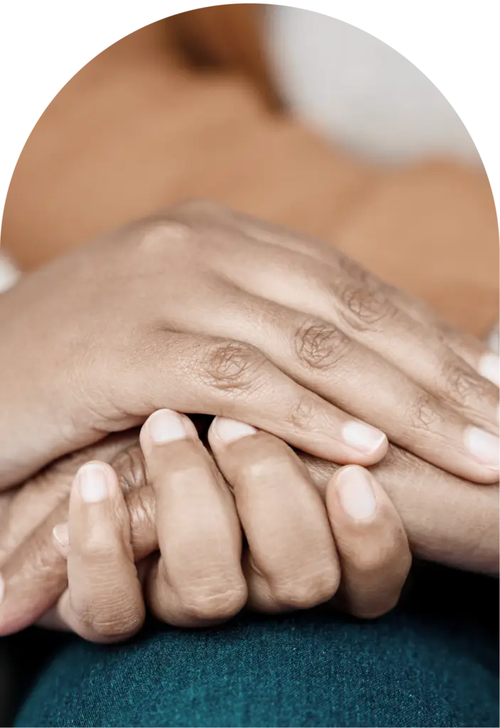 Closeup of hands holding another person's hands comforting them