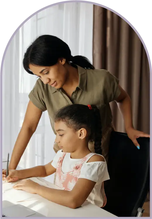 mom looking over daugher's shoulder as she does her homework