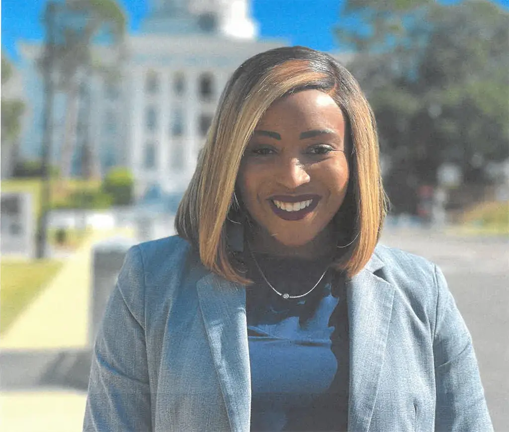 Jasmyne Crimiel smiling in front of the Capitol Building of Montgomery Alabama