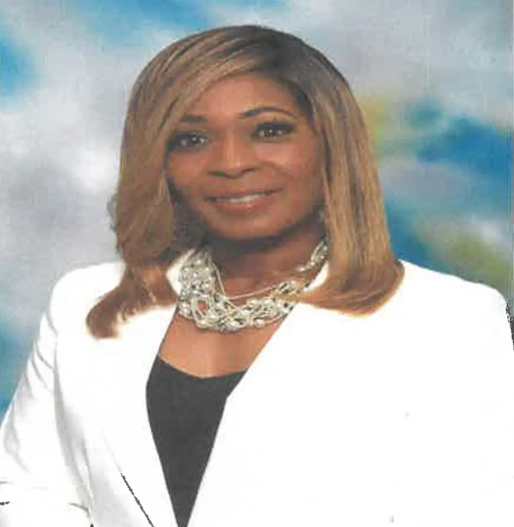 Jessica West Jackson smiling wearing a white jacket and a colorful background